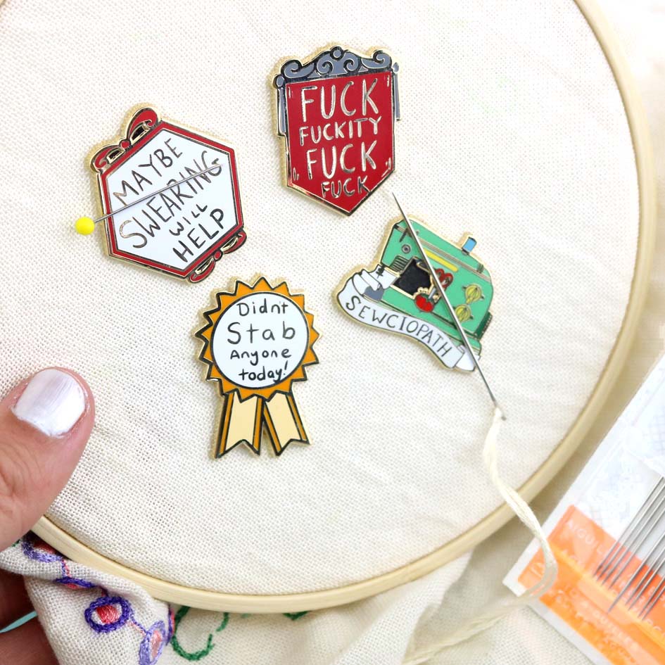 4 needle minders sitting in an imbroidery hoop, the first says Maybe Swearing Will Help, the seconde says Fuck Fuckity Fuck Fuck, the third says Didn't Stab Anyone Today and the forth needle minder says Sewciopath.