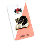 Lapel pin with a black cat on a book, 'I Read Banned Books' text, on backing card with brand logo.