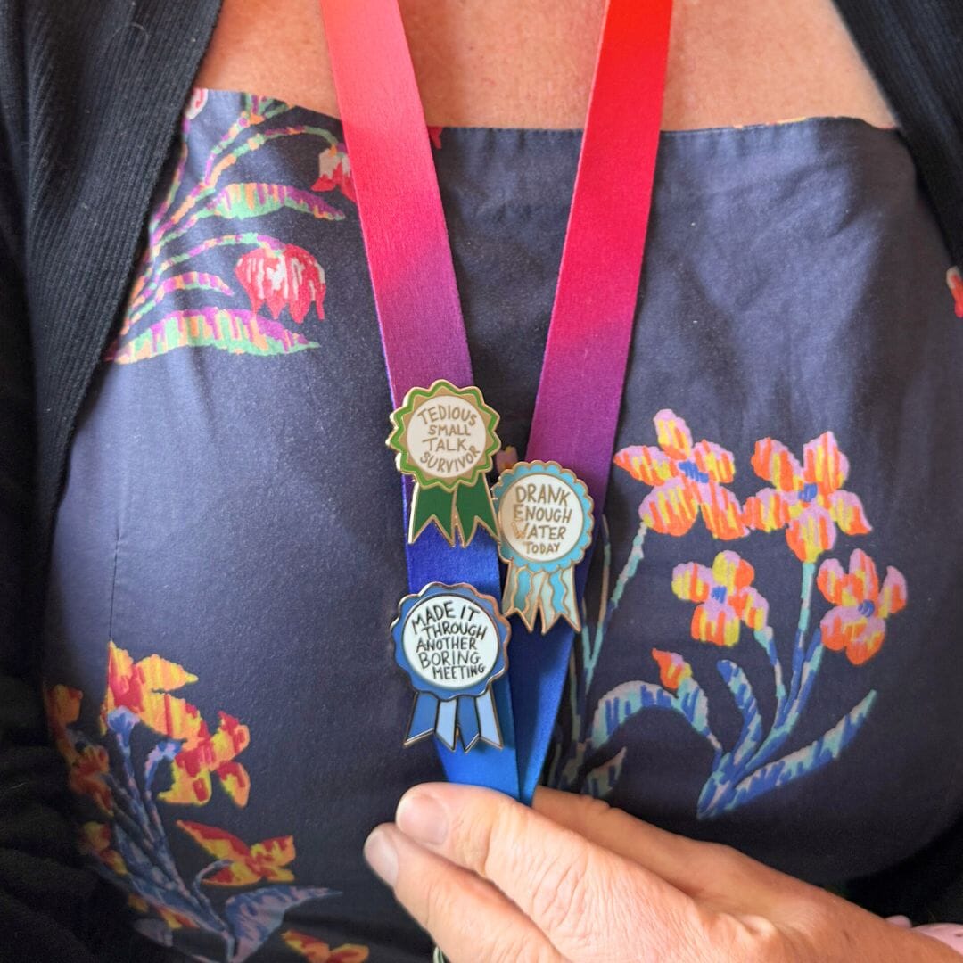 Three pins worn on a lanyard