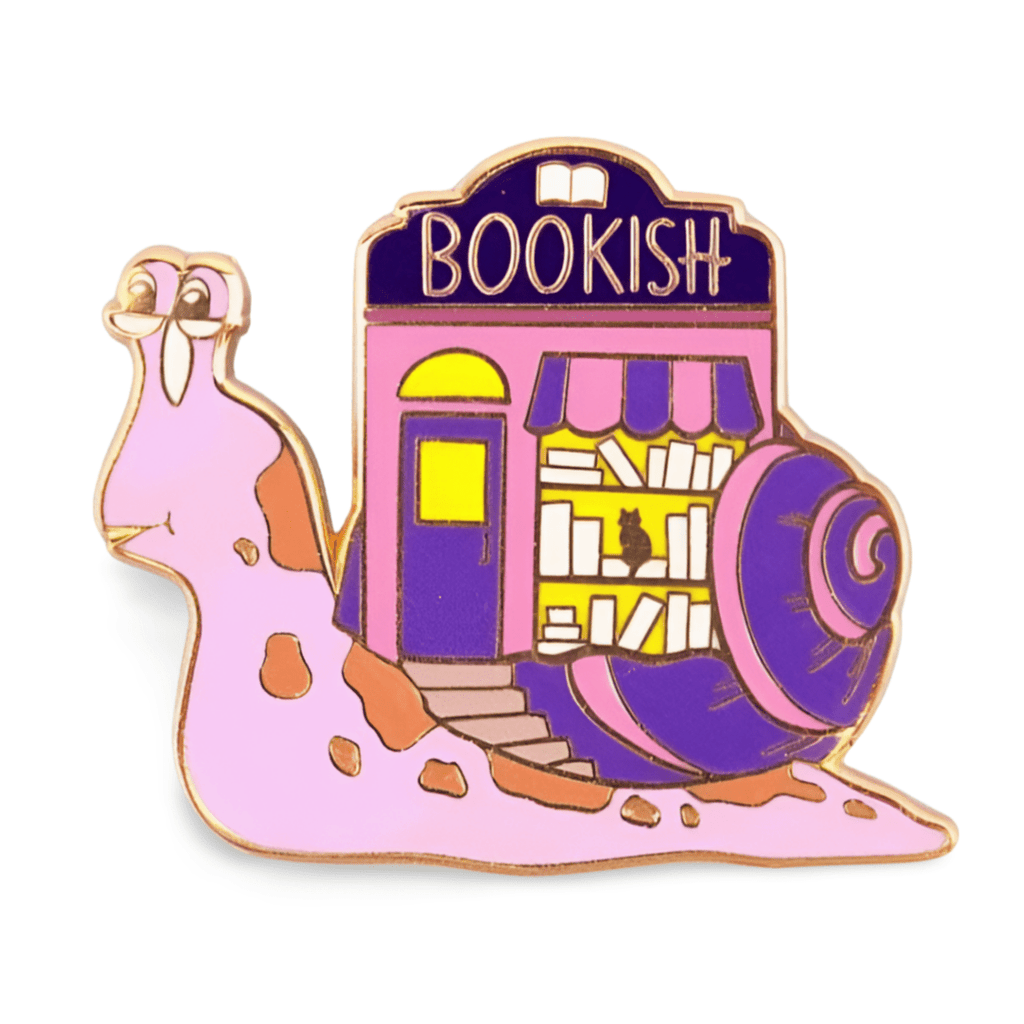 A hard enamel lapel pin on a white background. The pin says say Bookish. The pin design is a snail with a bookshop on its back.