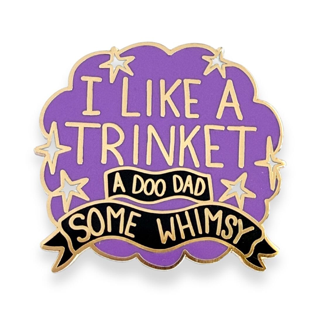 Purple and gold enamel pin with I like a trinket, a doo-dad, some whimsy design on a cloud background