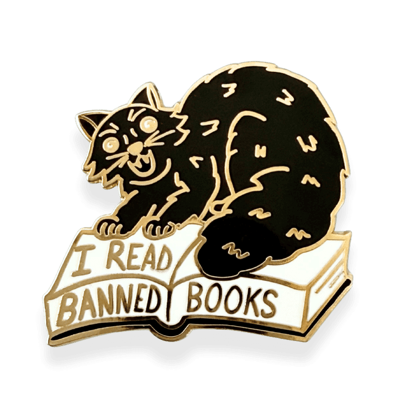 black cat hissing with arched back while standing on a open book with I REad Banned Books written on it.