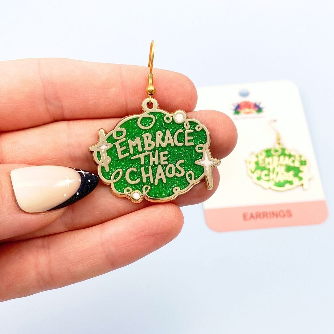 Embrace the chaos earrings - one being held with other on backing card in background
