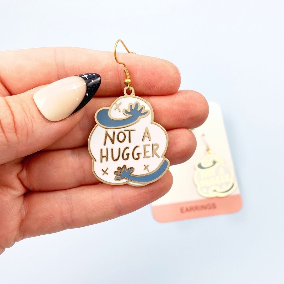 Not a hugger earrings - one being held with other in background on backing card