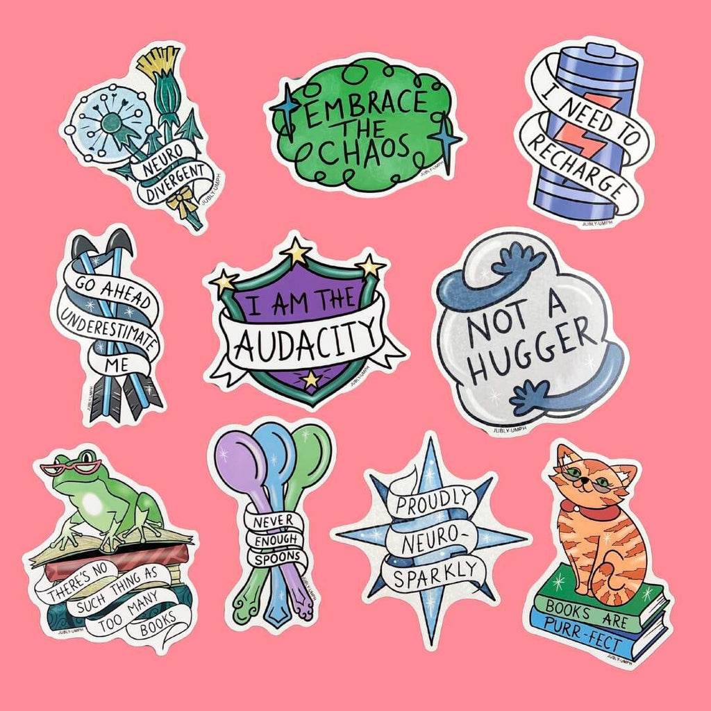 A group of vinyl stickers reading Neuro Divergent, Embrace the Chaos, There's No Such Thing As Too Many Books, I Need to Recharge, Proudly Neuro-Sparkly, Not a Hugger, Go Ahead Underestimate Me, Books Are Purr-fect, Never Enough Spoons and I am the Audacity.