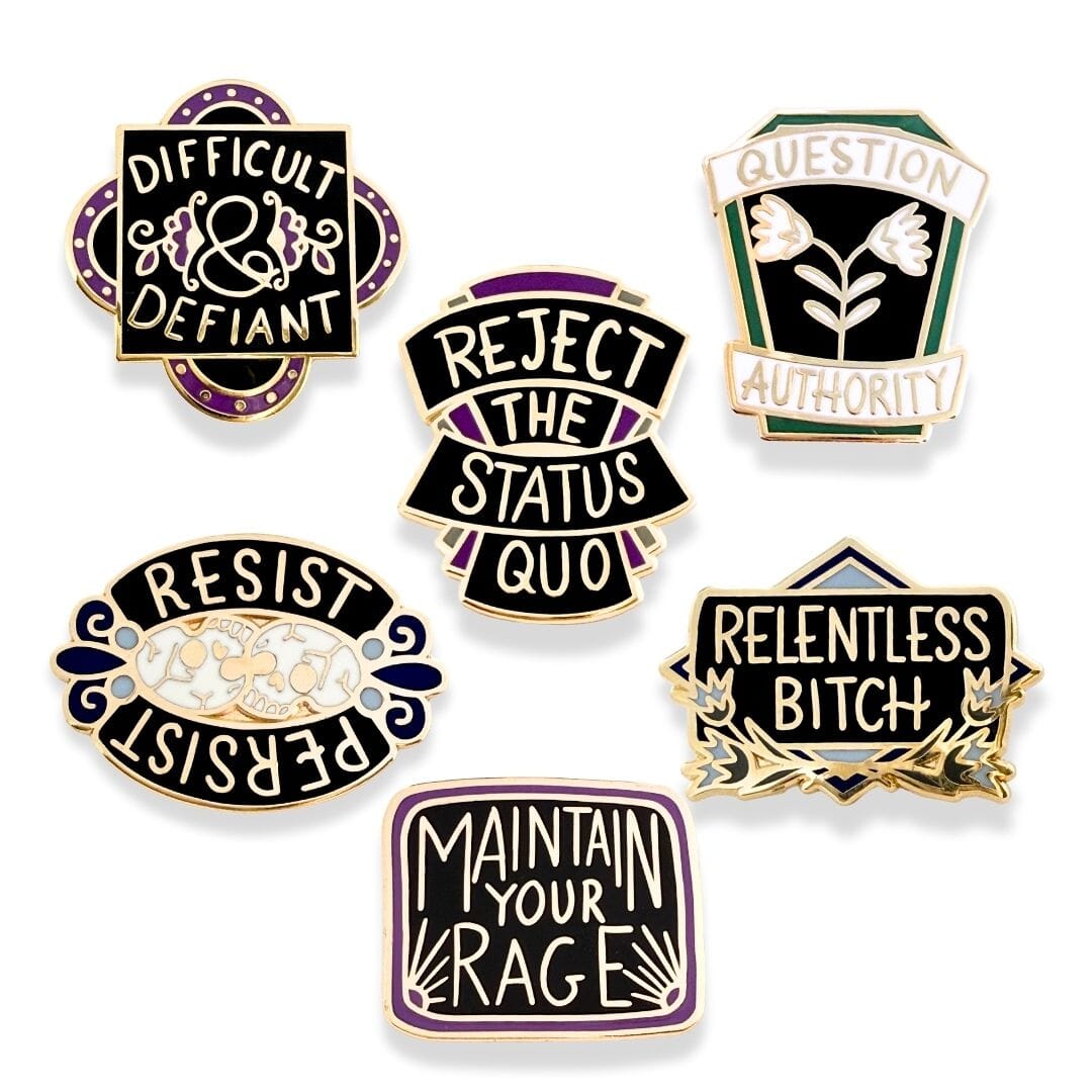 Set of six motivational pins with phrases like 'Difficult & Defiant', 'Reject the Status Quo', and 'Maintain Your Rage' on a white background.