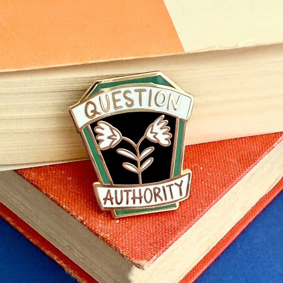 Pin with 'Question Authority' text on a colourful geometric background