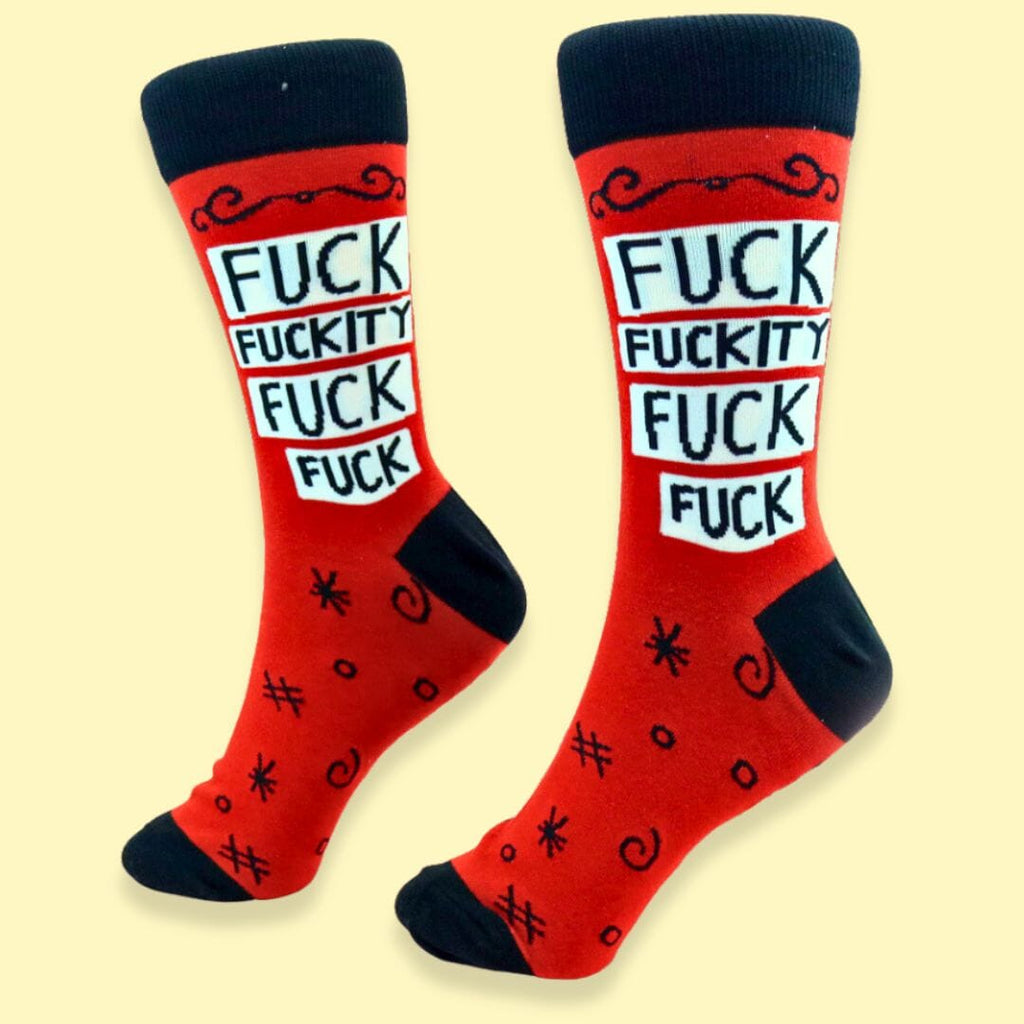 A pair of socks standing against a yellow background. The socks are red and black and read Fuck Fuckity Fuck Fuck.