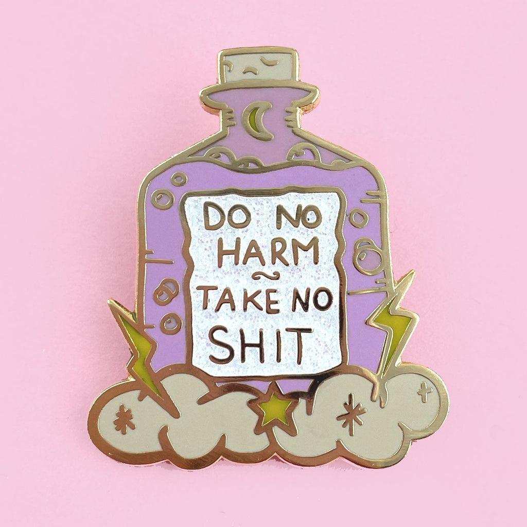 A hard enamel lapel pin on a pink background. The pin is purple and in the shape of a bottle with clouds and lightning bolts. The pin reads Do No Harm Take No Shit.