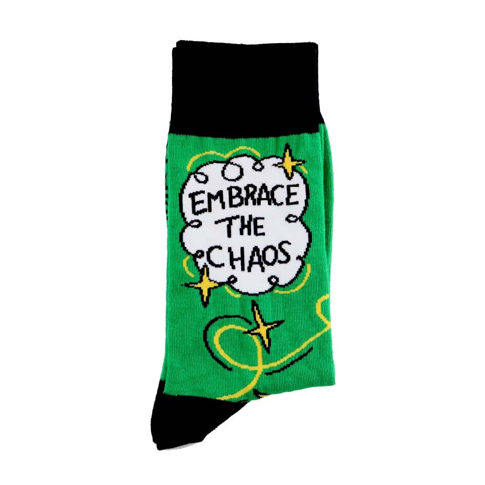 A pair of socks standing against a white background. The socks are green and gold and read Embrace The Chaos. 