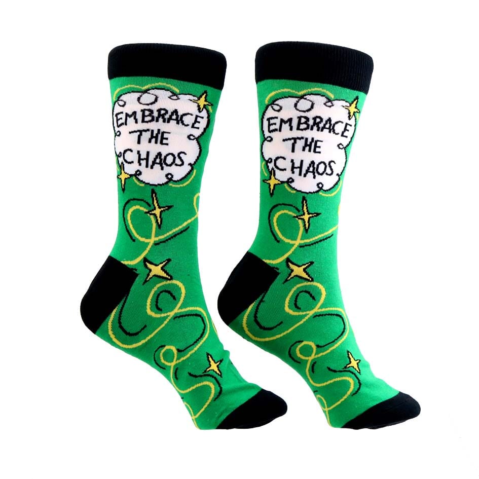A pair of socks standing against a white background. The socks are green and gold and read Embrace The Chaos. 