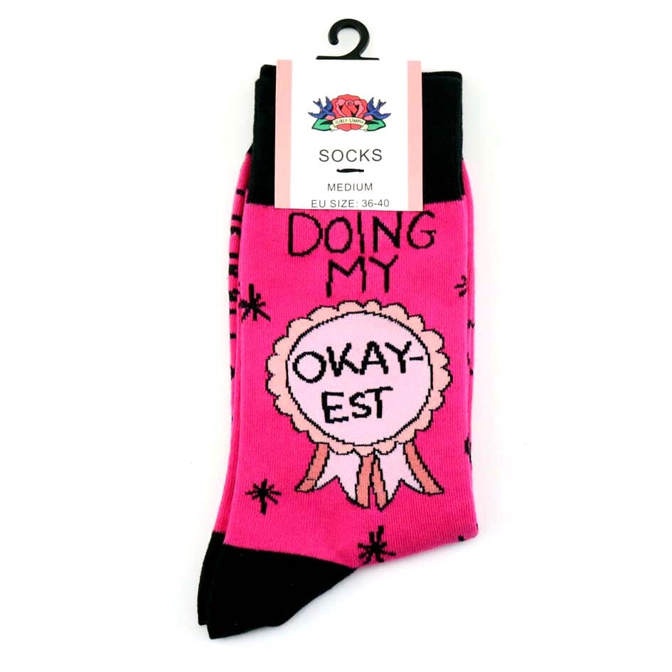 A pair of socks on a white background. The socks are pink and black and read Doing My Okay-est.
