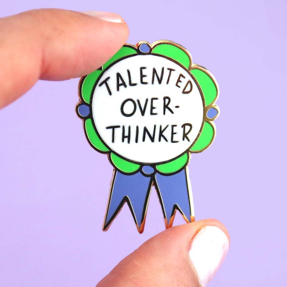 Talented Over Thinker Lapel Pin held by two fingers