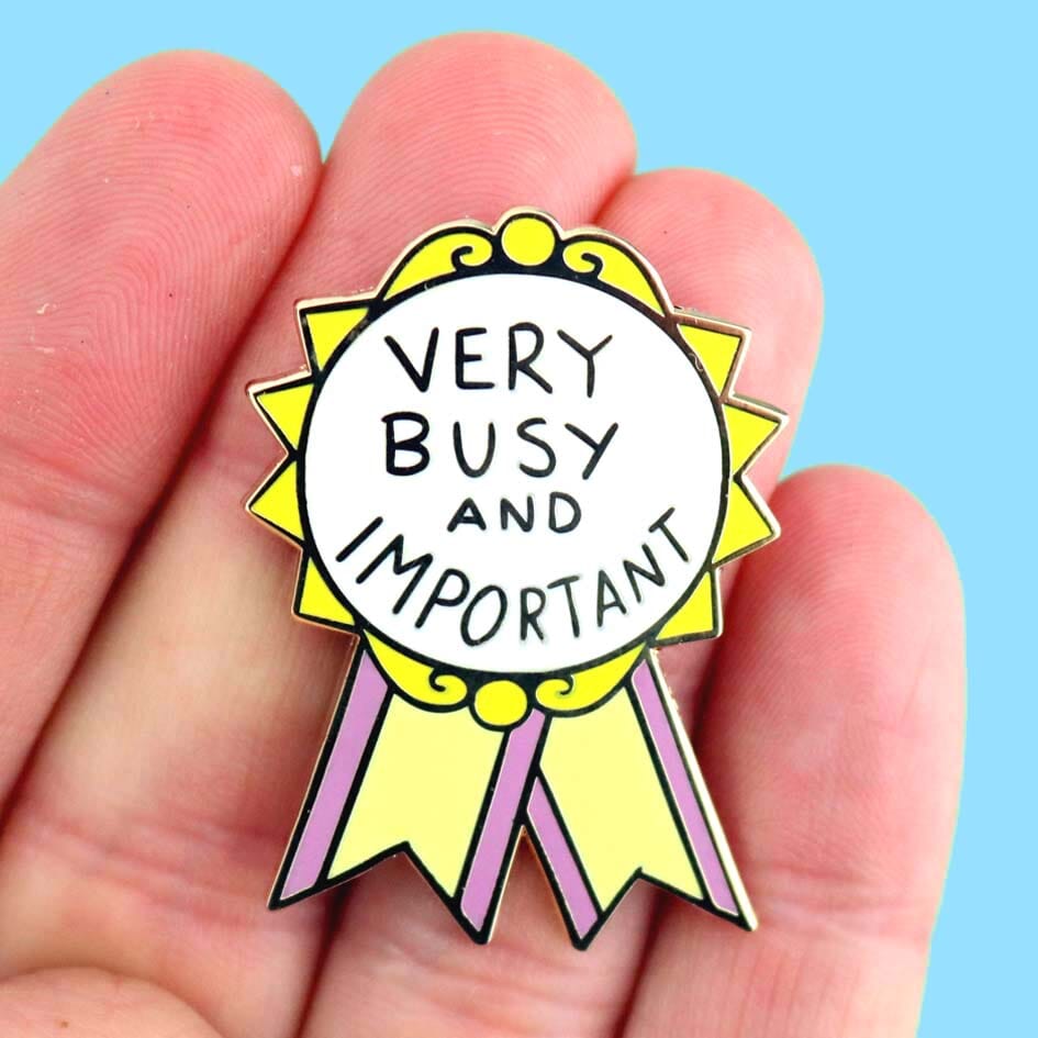 Very Busy and Important Lapel Pin held in hand