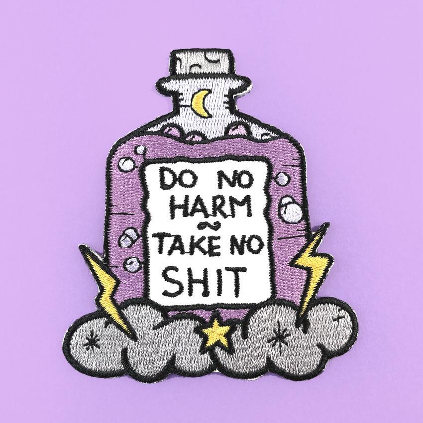 An iron on embroidered patch on purple background. The patch is purple and in the shape of a bottle with clouds and lightning bolts. The pin reads Do No Harm Take No Shit.