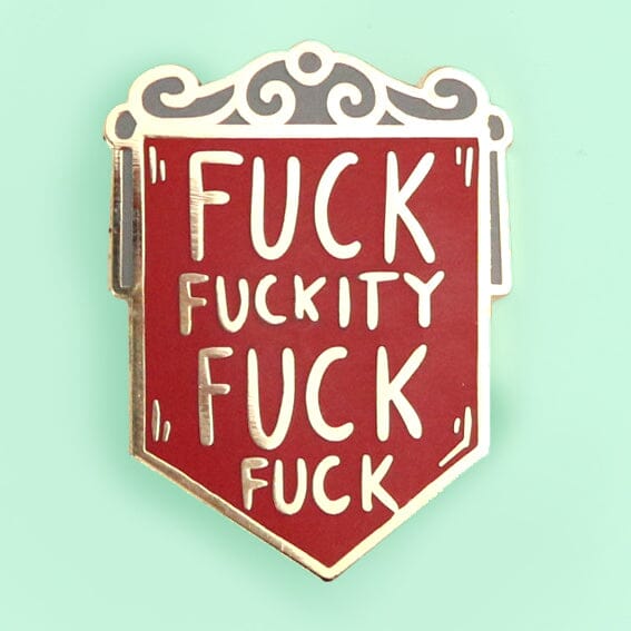 A hard enamel pin on a green background. The pin is in the shape of a red shield and reads Fuck Fuckity Fuck Fuck.