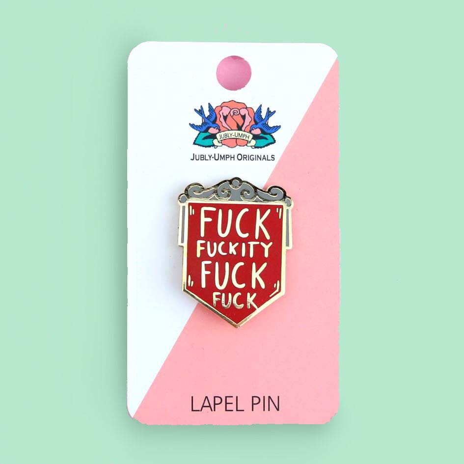 A hard enamel pin on a Jubly-Umph backing card. The pin is in the shape of a red shield and reads Fuck Fuckity Fuck Fuck.