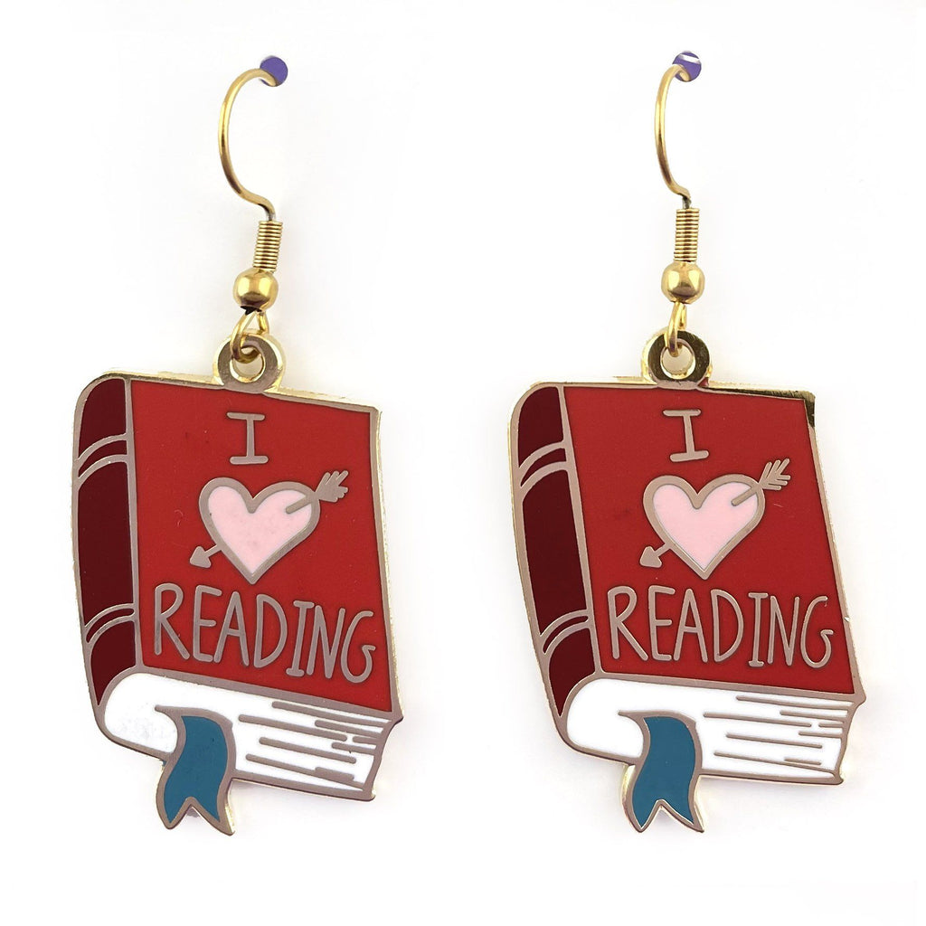 A pair of earrings displayed on a white background. The earrings are in the shape of a red book. The earrings read I (heart image) reading.