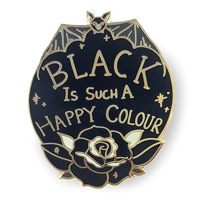 Black oval shaped lapel pin depicting a bat at the top, a black rose at the bottom, and the words 'Black is such a happy colour' in between.